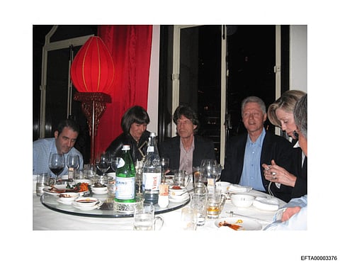 This undated photo provided by the US Justice Department on December 19, 2025 shows Jeffrey Epstein's associate Ghislaine Maxwell (2nd L), pop star Mick Jagger (C) and former president Bill Clinton (2nd R), along with unidentified guests in an undidentified location.