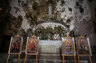 Father Dimitri Dogum prepares for the Christmas Eve mass at the Church of Saint Peter, where the first religious gathering was held in the 1st century, the birth of Christianity, on December 24, 2025 in Antakya.