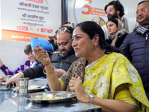 Delhi Chief Minister Rekha Gupta eats food during the inauguration of Atal Canteen, in New Delhi on Thursday, Dec 25, 2025.