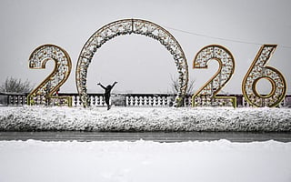 A girl enjoys snow in front of New Year 2026 numerals at Vorobyovy Hills observation point in Moscow on December 26, 2025.