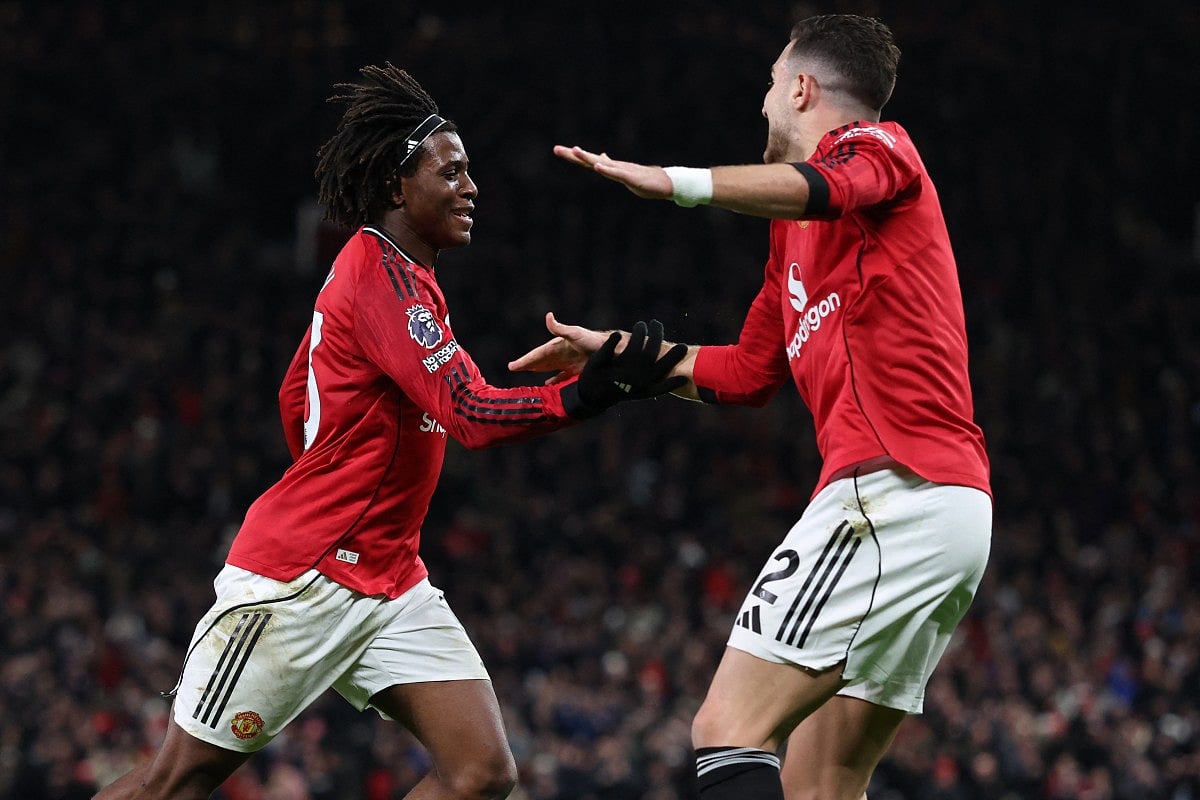 Manchester United's Danish defender #13 Patrick Dorgu (L) celebrates with Manchester United's Portuguese defender #02 Diogo Dalot (R) after scoring the opening goal of the English Premier League football match between Manchester United and Newcastle United at Old Trafford in Manchester, north west England, on December 26, 2025.