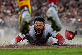 St. Louis Cardinals' Victor Scott II, bottom, scores against the San Francisco Giants on Brendan Donovan's double during the ninth inning of a baseball game, Sept. 23, 2025, in San Francisco.