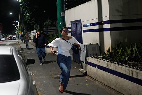 Pedestrians run after explosions and low-flying aircraft were heard in Caracas, Venezuela, Saturday, Jan. 3, 2026. 