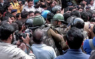 Security forces reach the spot as BJP workers, along with locals, hold a protest against the Congress delegation at the Bhagirathpura area on the water contamination issue, in Indore on Saturday. 