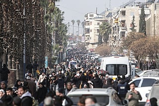 Residents carry their belongings as they flee Aleppo's Ashrafieh Kurdish neighbourhood on January 7, 2026.