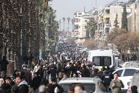 Residents carry their belongings as they flee Aleppo's Ashrafieh Kurdish neighbourhood on January 7, 2026.