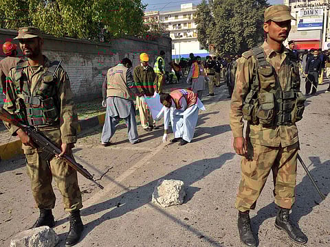 Pakistani army soldiers stand guard at a suicide blast site in Peshawar on December 24, 2009. 
