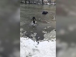 Firefighter braves icy river to save car in Bosnia