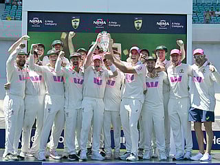 Australian players celebrate with the Waterford Crystal Ashes Trophy at the end of the fifth Ashes cricket Test between Australia and England at Sydney Cricket Ground on January 8, 2026. 