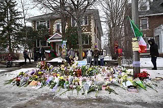 People gather around a makeshift memorial honoring Renee Good who was fatally shot by a federal law enforcement agent near the site of the shooting in Minneapolis, Thursday, Jan. 8, 2026. (AP Photo/Tom Baker)