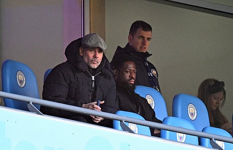 Manchester City's Spanish manager Pep Guardiola watches from the stands during the English FA Cup third round football match between Manchester City and Exeter City at the Etihad Stadium in Manchester, north west England, on January 10, 2026.