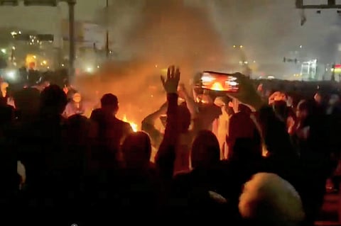 In this frame grab from footage circulating on social media shows protesters dancing and cheering around a bonfire as they take to the streets despite an intensifying crackdown as the Islamic Republic remains cut off from the rest of the world, in Tehran, Ion January 9, 2026. 