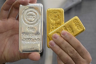 A jeweller shows gold and silver bars at his shop in downtown Kuwait City on January 12, 2026.