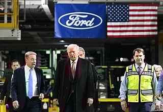 US President Donald Trump speaks with Ford executive chairman Bill Ford (L) and Ford CEO Jim Farley (R) as he tours Ford Motor Company's River Rouge complex in Dearborn, Michigan, on January 13, 2026.