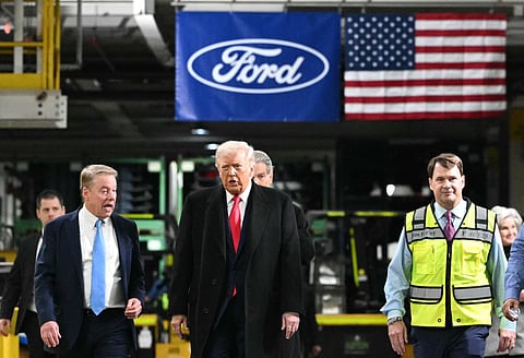 US President Donald Trump speaks with Ford executive chairman Bill Ford (L) and Ford CEO Jim Farley (R) as he tours Ford Motor Company's River Rouge complex in Dearborn, Michigan, on January 13, 2026.