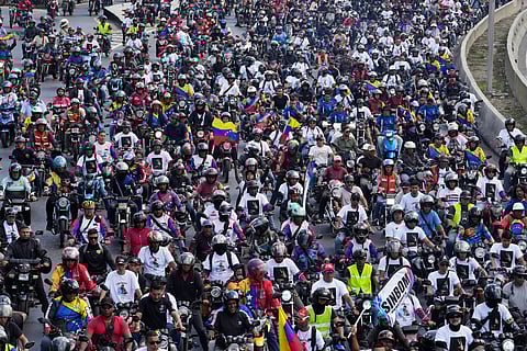 Supporters of former Venezuelan President Nicolas Maduro ride through the streets calling for his release as he faces trial in the United States after being captured by U.S. forces, in Caracas, Venezuela, Tuesday, Jan. 13, 2026. (AP Photo/Matias Delacroix)