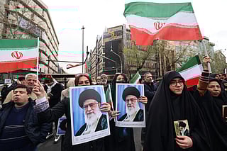 Iranian women hold portraits of Iran’s Supreme Leader Ayatollah Ali Khamenei during the funerals of security forces personnel killed in recent protests in Tehran on January 14, 2026.