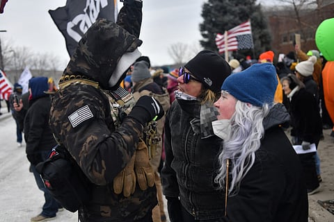 Protesters (R) are confronted by an ICE supporter during a demonstration outside the Bishop Whipple Federal Building in Minneapolis, Minnesota, on January 15, 2026.