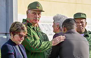 Cuba's President Miguel Diaz-Canel consoles relatives of some of the 32 Cuban soldiers killed during the US incursion in Venezuela during their funeral at Colon cemetery in Havana on January 16, 2026.