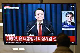 A man watches South Korea's President Yoon Suk Yeol speak during a news broadcast on a television at a train station in Seoul on December 3, 2024, after he declared emergency martial law, saying the step was necessary to protect the country from "communist forces" amid parliamentary wrangling over a budget bill.