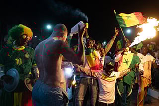 Senegal football supporters celebrate at a fan zone at the Obelisk Square in Dakar on January 18, 2026 after Senegal won the Africa Cup of Nations (CAN) final football match between Senegal and Morocco played in Rabat, Morocco.