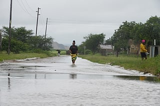 People walk through floodwaters in Nkomazi, Mpumalanga Province, South Africa, on Friday, Jan. 16, 2026. (AP Photo/Alfonso Nqunjana)