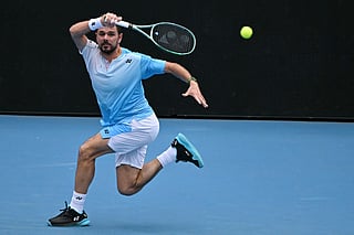 Switzerland’s Stan Wawrinka hits a return against Serbia’s Laslo Djere during their men's singles match on day two of the Australian Open tennis tournament in Melbourne on January 19, 2026.