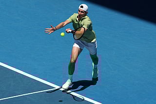 France's Ugo Humbert hits a return to USA's Ben Shelton during their men's singles match on day three of the Australian Open tennis tournament in Melbourne on January 20, 2026.