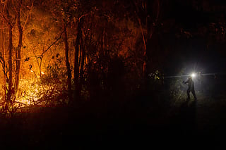Firefighters battle flames spreading through a forested area near Concepcion, Chile, Tuesday, Jan. 20, 2026. (AP Photo/Javier Torres)