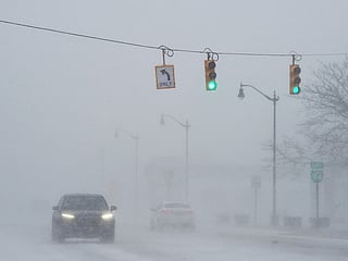Blowing and drifting snow makes travel difficult Wednesday, Jan. 14, 2026, in downtown Benton Harbor, Mich., as a winter storm moves across Southwest Michigan.