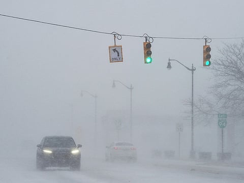Blowing and drifting snow makes travel difficult Wednesday, Jan. 14, 2026, in downtown Benton Harbor, Mich., as a winter storm moves across Southwest Michigan.