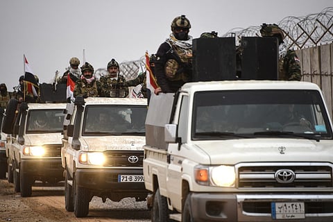 Members of Iraq’s Popular Mobilization Forces drive along the Syrian border in northwestern Iraq in January.