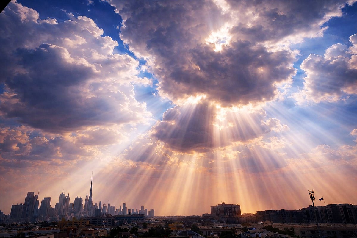 Dramatic sunbeams pierce clouds, casting a golden glow over Dubai’s iconic skyline, highlighting towers and horizon at dusk photographed by Serena H.