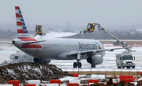 Ground crews de-ice an American Airlines jet at Dallas Fort Worth International Airport on January 24, 2026 in Dallas, Texas.
