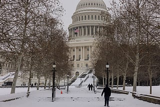 People walk in front of the US Capitol on January 25, 2026 in Washington, DC. A massive winter storm is expected to bring frigid temperatures, ice, and snow to millions of Americans across the nation.