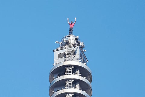 US rock climber Alex Honnold raises his arms from the top of the Taipei 101 building after he successfully free soloed the landmark skyscraper without ropes or safety gear in Taipei on January 25, 2026.