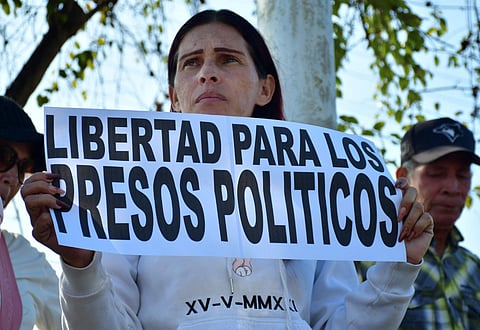 A woman shows a sign that reads "Freedom for political prisoners" during a demonstration to demand the freedom of Venezuelan political prisoners in front of Tocuyito prison in Tocuyito, near Valencia, Venezuela on January 20, 2026.