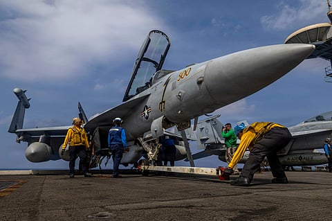 Sailors preparing a Boeing EA-18G Growler on the flight deck of the Nimitz-class aircraft carrier USS Abraham Lincoln in the Indian Ocean.