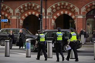 FILE - Police officers patrol the King's Cross train station, in London, Monday, Nov. 3, 2025. 