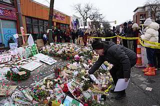 People visit a makeshift memorial for 37-year-old Alex Pretti, who was fatally shot by a U.S. Border Patrol officer over the weekend, Monday, Jan. 26, 2026, in Minneapolis. (AP Photo/Adam Gray)
