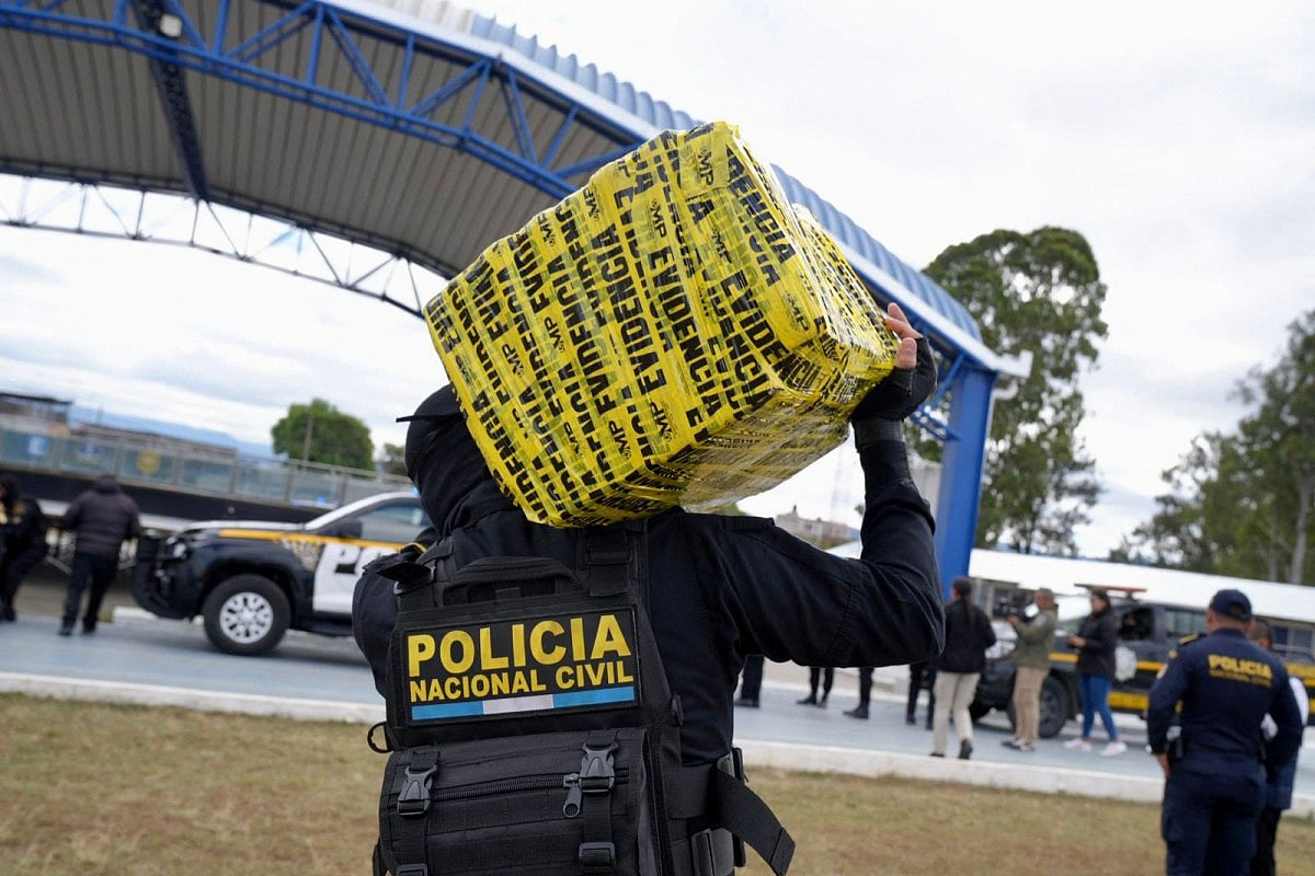 This handout picture released by Guatemala's National Civil Police press office shows members of the National Civil Police carrying packages of the seized 4.9 tonnes of cocaine during an operation at the port of Quetzal, in Escuintla, Guatemala City, on January 28, 2026.