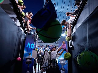 Iga Swiatek of Poland signs autographs after defeating Anna Kalinskaya of Russia in their third round match at the Australian Open tennis championship in Melbourne, Australia.