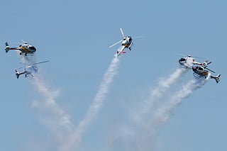 Helicopters from the Spanish Air and Space Force's ASPA patrol perform an aerial display over Ipanema Beach in Rio de Janeiro, Brazil.