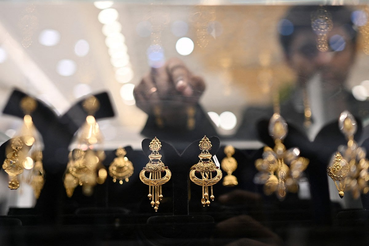 A man checks gold earrings at a jewellery store in New Delhi on January 31, 2026.
