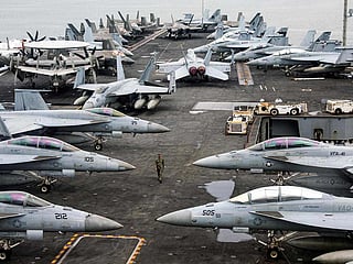 File photo: A US Navy officer walks past fighter jets sitting on the flight deck of aircraft carrier USS Abraham Lincoln. A US naval strike group led by this aircraft carrier has deployed to Middle Eastern waters, the US said on January 26, 2026. 