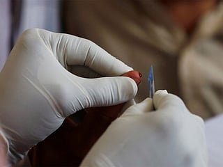 A medical worker draws blood for a HIV test