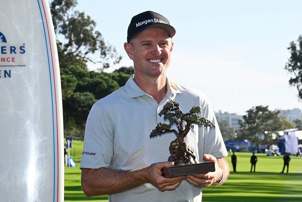 Justin Rose, of England, holds the winner's trophy at the Farmers Insurance Open golf tournament Sunday, Feb. 1, 2026, at Torrey Pines in San Diego. 