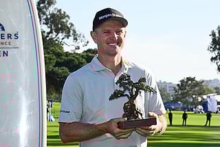 Justin Rose, of England, holds the winner's trophy at the Farmers Insurance Open golf tournament Sunday, Feb. 1, 2026, at Torrey Pines in San Diego. 