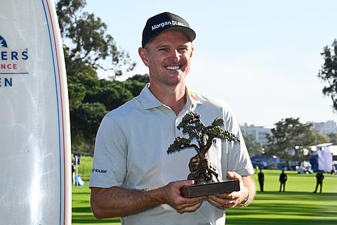 Justin Rose, of England, holds the winner's trophy at the Farmers Insurance Open golf tournament Sunday, Feb. 1, 2026, at Torrey Pines in San Diego. 