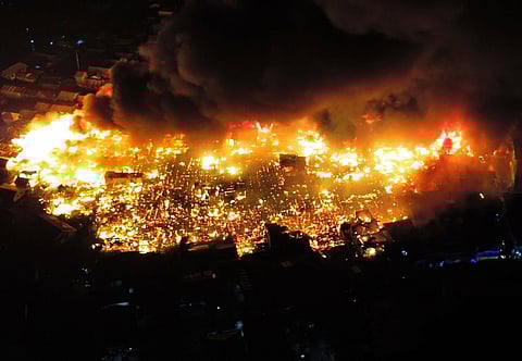 Aerial footage captures the harrowing scene: flames engulfing rows of rooftops, thick smoke billowing into the night sky, and structures collapsing in a sea of orange inferno (left). At right, the fire's aftermath.
